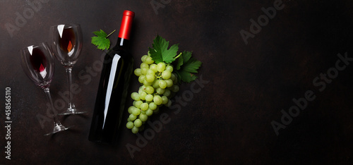 Two red wine glasses, wine bottle and grape