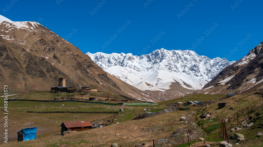 View of the Ushguli village at the foot of Mt. Shkhara. Lamaria Monastery, old Rock tower