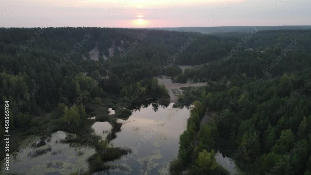 Sunrise over the land of forests and lakes.Flight over ferests small lakes in the early morning at sunrise.