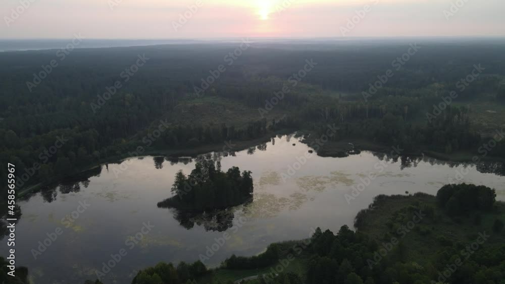 Sunrise over the land of forests and lakes.Flight over ferests small lakes in the early morning at sunrise. Sunrise over the land of forests and lakes.Flight over ferests small lakes in the early morning at sunrise.