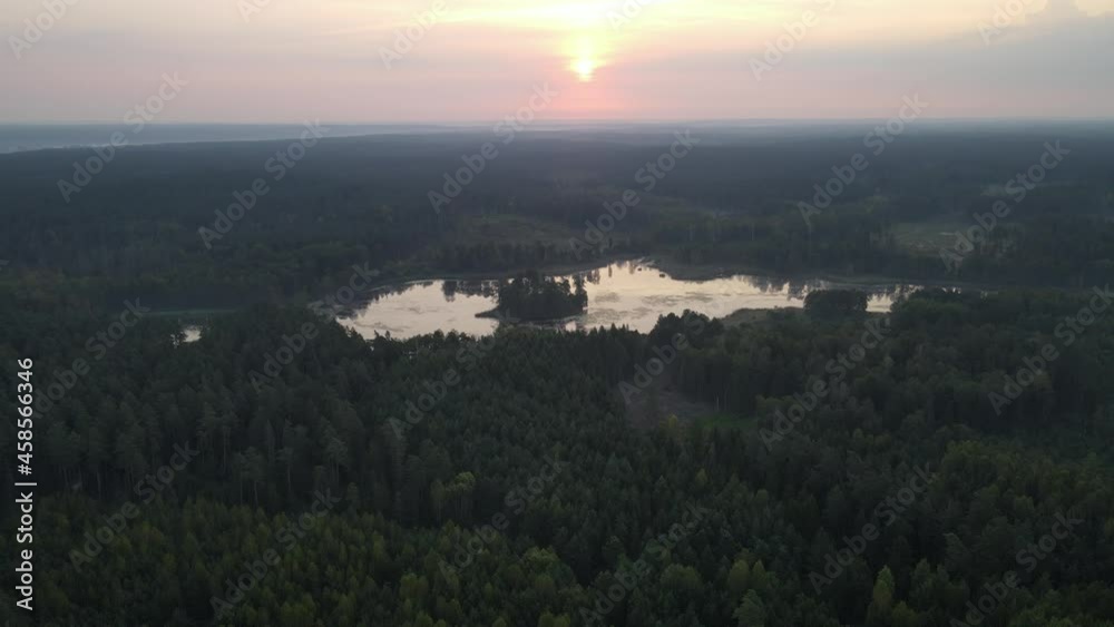 Sunrise over the land of forests and lakes.Flight over ferests small lakes in the early morning at sunrise. Sunrise over the land of forests and lakes.Flight over ferests small lakes in the early morning at sunrise.