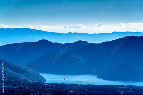 View of dark blue waters of Lake Ashi (elev. 723 m / 2,372 ft) in Hakone mountains as seen from summit of Mt. Kintoki (elev. 1,212 m / 3,976 ft) on clear winter day in Shizuoka Prefecture, Japan.