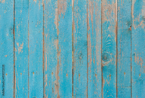Wooden background.An old blue wooden fence of painted boards with cracks and nails.