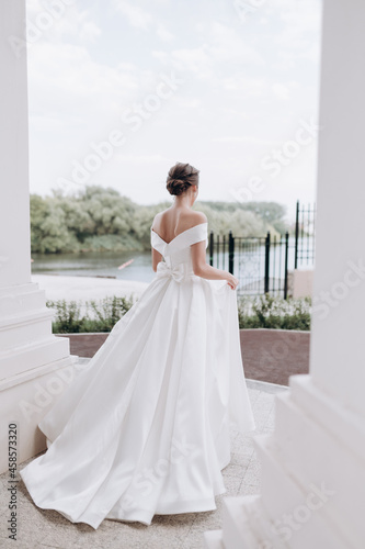 beautiful bride in a white dress walking on the street summer wedding youth hairstyle