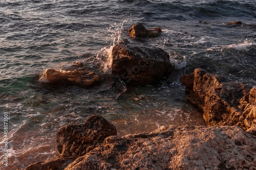Fototapeta Naklejka Na Ścianę i Meble -  Stones on the seashore. Rocky beach at sunset. Natural background.