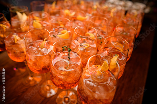 selective focus on glasses of aperol spritz cocktail with ice cubes and orange slices photo