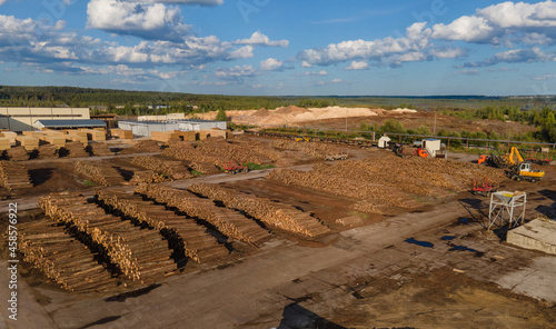 Wooden logs and modern industrial vehicles at sawmill photo