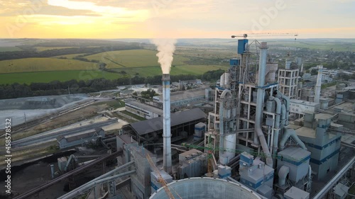 Aerial view of cement factory tower with high concrete plant structure at industrial production area. Manufacturing and global industry concept.