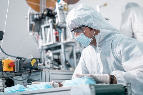 Scientists wearing uniform protection. Check the manufacturing process of face masks. In a laboratory at industry plants. The concept for security and protection coronavirus covid-19.