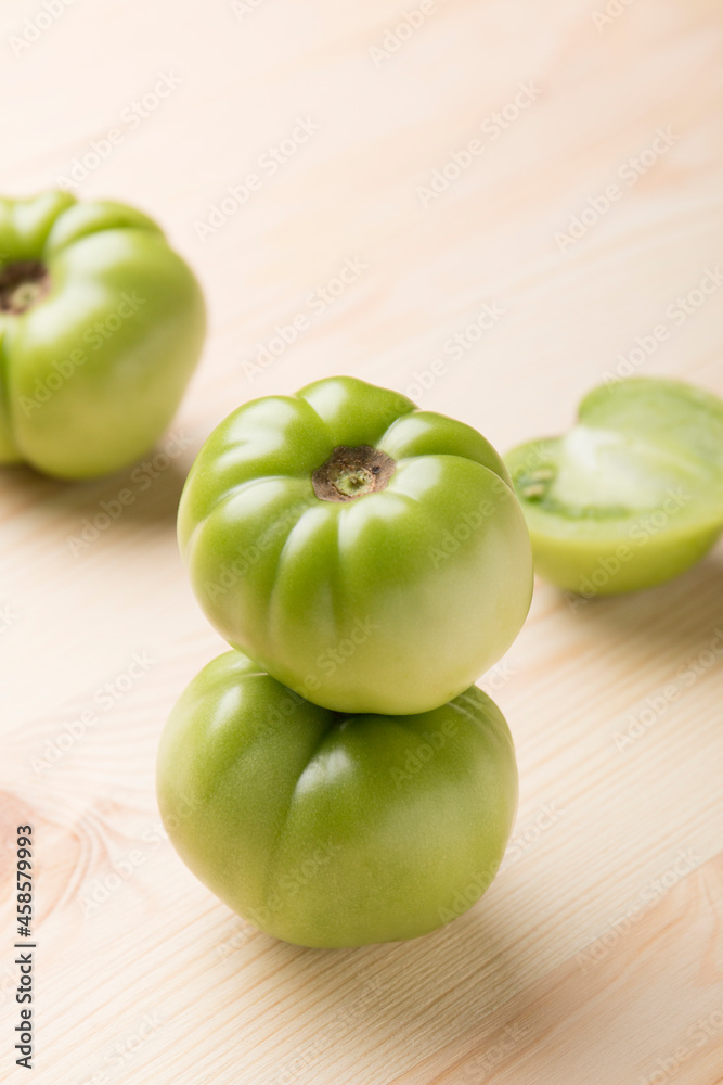 Green tomatoes for conservation on a wooden background. Unripe tomatoes for harvesting.