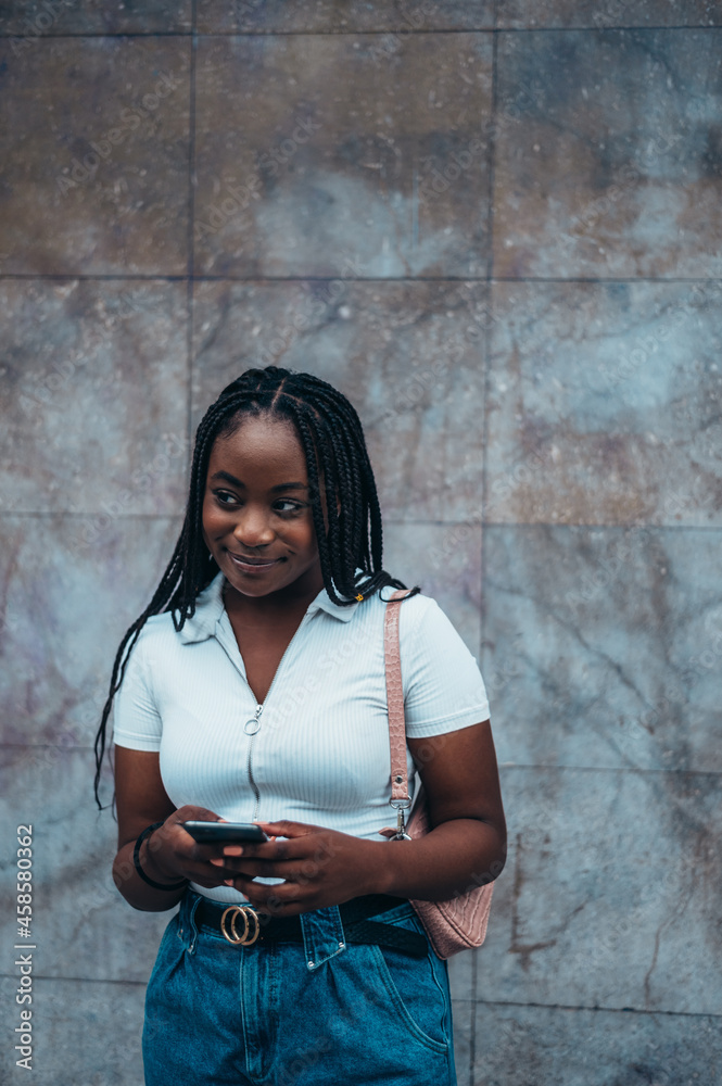Beautiful african american woman using smartphone while out in the city