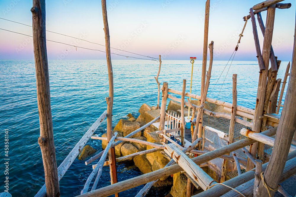 Trabocco San Giacomo in Ortona at sunset, Abruzzo. Trabucco a sort of Trebuchet, traditional wooden fishing house in southern Italy, on Costa dei Trabocchi (Coast Of the Trabocchi). UNESCO heritage Trabocco San Giacomo in Ortona at sunset, Abruzzo. Trabucco a sort of Trebuchet, traditional wooden fishing house in southern Italy, on Costa dei Trabocchi (Coast Of the Trabocchi). UNESCO heritage