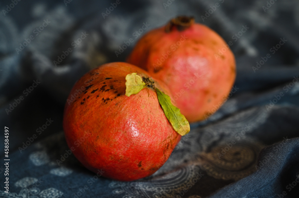 A whole pomegranate is lying on the wooden embankment tablecloths A whole pomegranate is lying on the wooden embankment tablecloths