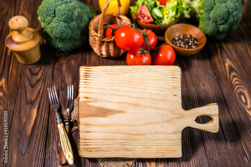 A cutting board with copy space. Mock up. A place for the restaurant's menu. Mix of colorful assorted fresh vegetables. Balanced nutrition concept for diet.