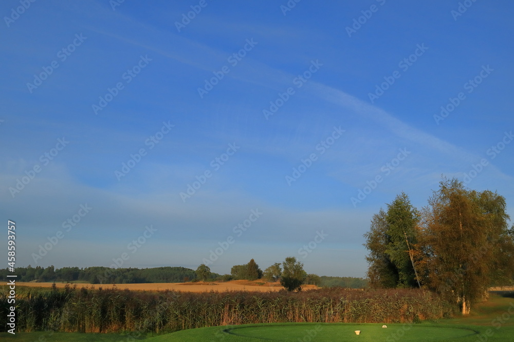 Fototapeta premium Partly golf course and farm land. Swedish countryside. Nice summer photo with sunlight in the air. Vallentuna, Stockholm, Sweden, Scandinavia, Europe.