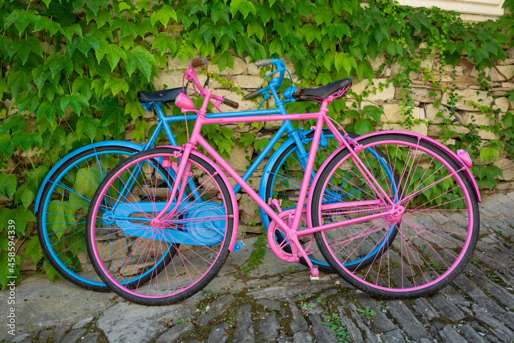 Two old bicycles, blue and pink