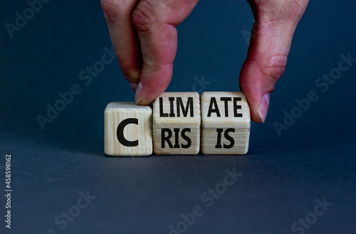 Climate crisis and change symbol. Businessman turns wooden cubes with words 'Climate crisis'. Beautiful grey background. Climate change and ecological crisis concept. Copy space.