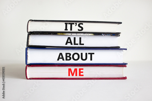 It is all about me symbol. Books with words 'It is all about me'. Beautiful white background. Businessman hand. Copy space. Business and it is all about me concept. photo