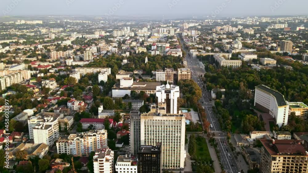 Aerial drone view of Chisinau downtown. Panorama view of multiple buildings, Parliament, Presidency, roads with moving cars and lush trees. Sunset. Moldova Aerial drone view of Chisinau downtown. Panorama view of multiple buildings, Parliament, Presidency, roads with moving cars and lush trees. Sunset. Moldova