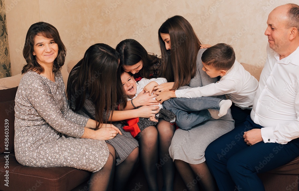 Fototapeta premium Christian large family. Big family at home on the couch. Family evenings. Parents' love for children 