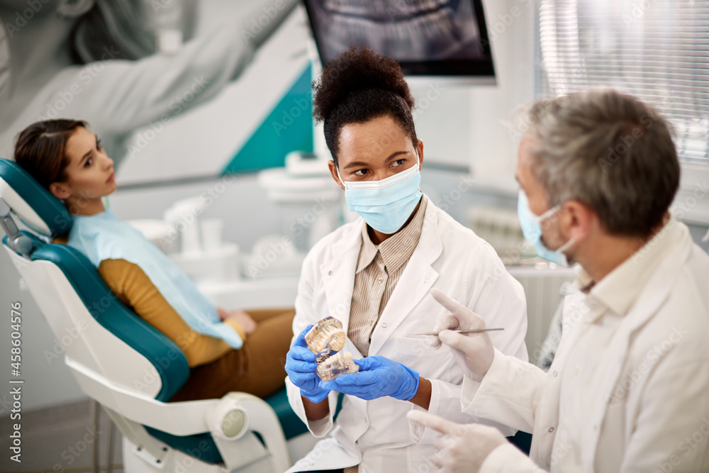 Two dentists discussing about dental health of their patient at dentist's office. Two dentists discussing about dental health of their patient at dentist's office.