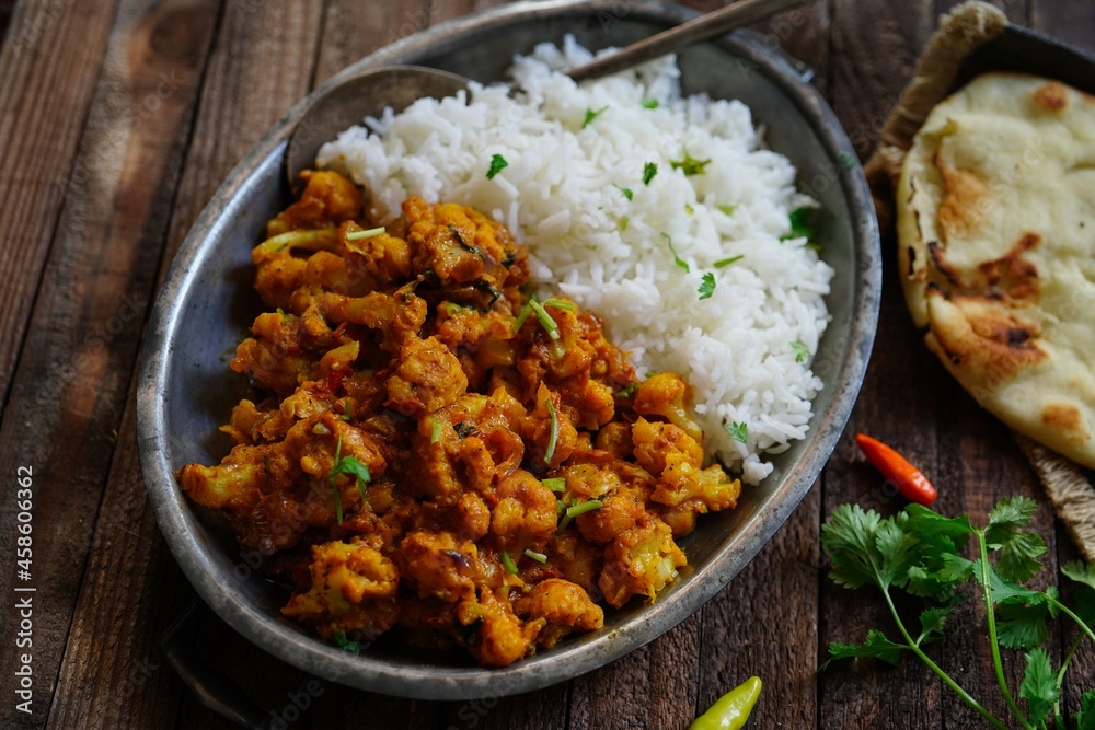 Cauliflower tikka masala or gobi curry served with rice and roti, selective focus Cauliflower tikka masala or gobi curry served with rice and roti, selective focus
