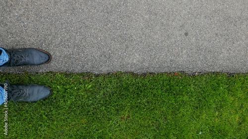 фотографія Walk the line with black leather shoes between grass and asphalt