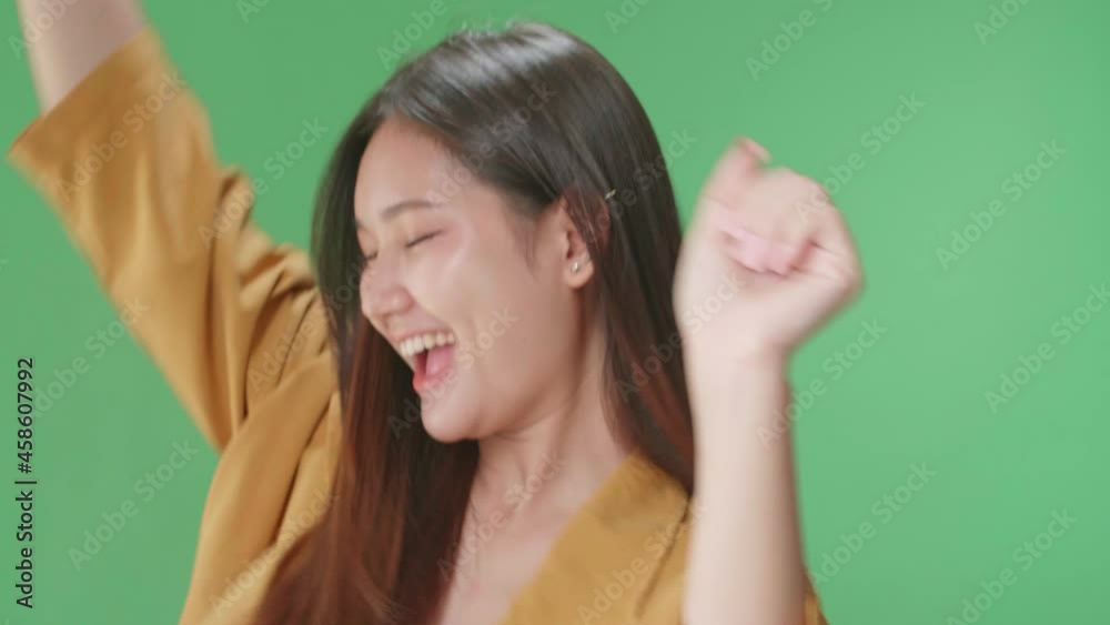 Close Up Of The Smiling Asian Woman Dancing Sides On Green Screen In A Green Screen Studio
