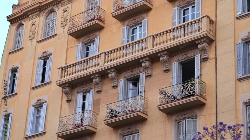 Old residential building made in classic style with a tree in front of it in Barcelona, Spain Old residential building made in classic style with a tree in front of it in Barcelona, Spain