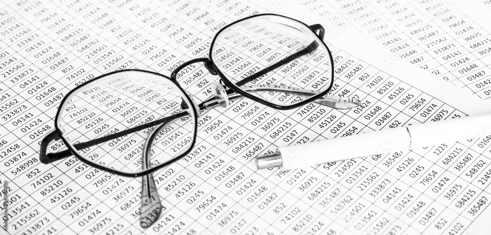 finance business calculation with glasses, tables with numbers and pen. business concept. financial literacy. accounting of income and expenses finance business calculation with glasses, tables with numbers and pen. business concept. financial literacy. accounting of income and expenses