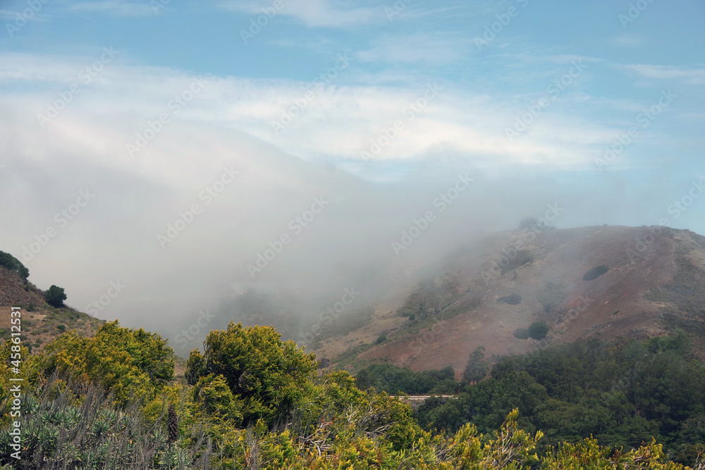 Central California coastal mountains with fog coming in from the ocean on an early summer day