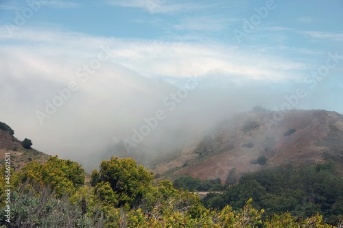 Central California coastal mountains with fog coming in from the ocean on an early summer day © Jack