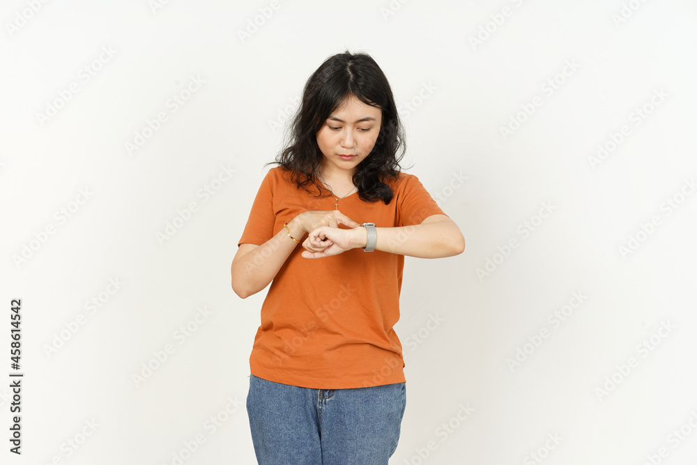Looking at the watch of beautiful asian woman Wearing orange T-shirt isolated on white background Looking at the watch of beautiful asian woman Wearing orange T-shirt isolated on white background