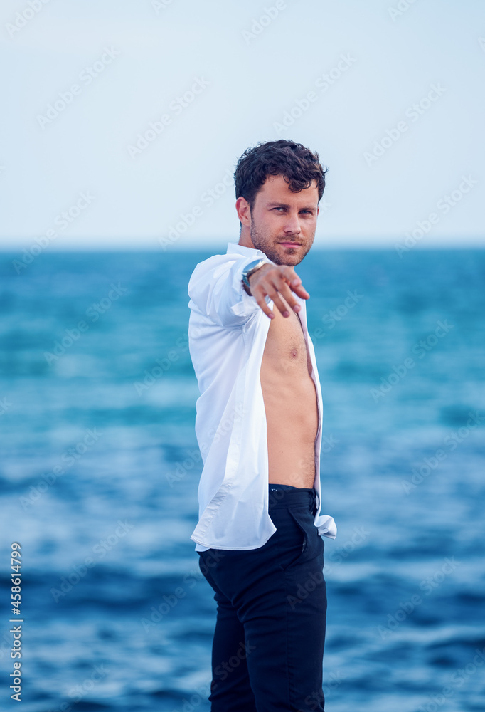 Stylish man reaching out hand on seashore Stylish man reaching out hand on seashore