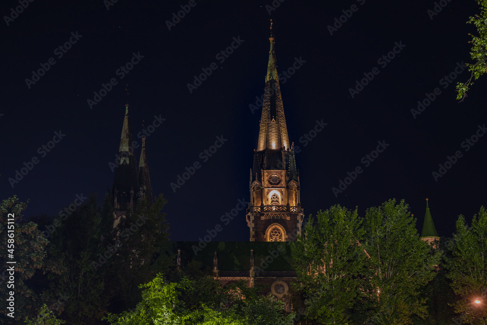 high tower of church night landmark foreshortening from below dark sky with strats background
