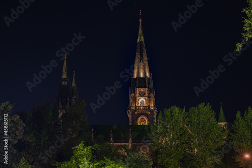 high tower of church night landmark foreshortening from below dark sky with strats background photo