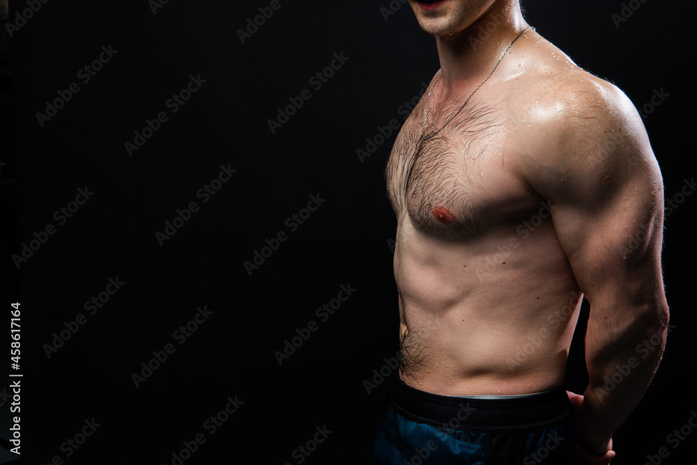 Fototapeta premium Man on black background keeps dumbbells pumped up in fitness active chest black, arm muscular exercise bodybuilder dumbbell, male pectoral. Attractive skin metal, people fit hands behind your back