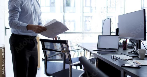 RED camera video of Caucasian male employee dressed in formal wear spending working time in modern office interior with high tech for doing exchange trade, professional with documents in workspace
