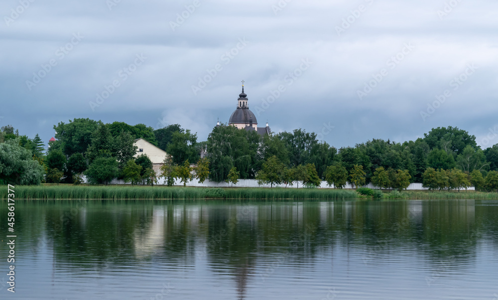 Lake overlooking the old Farny Church in Nesvizh, Belarus. Beautiful summer landscape with architectural elements.