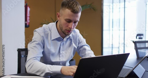 RED camera video of Caucasian male employee dressed in formal wear searching web platform for doing trade during work time, happy businessman enjoying finish of startup project
