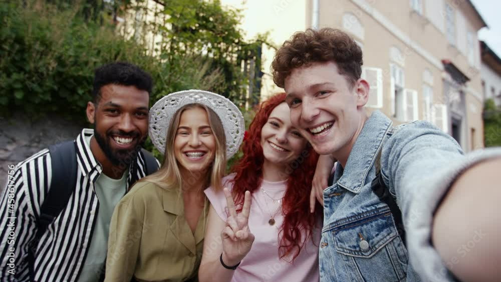 Group of young people outdoors on trip in town, taking selfie and looking at camera. Group of young people outdoors on trip in town, taking selfie and looking at camera.