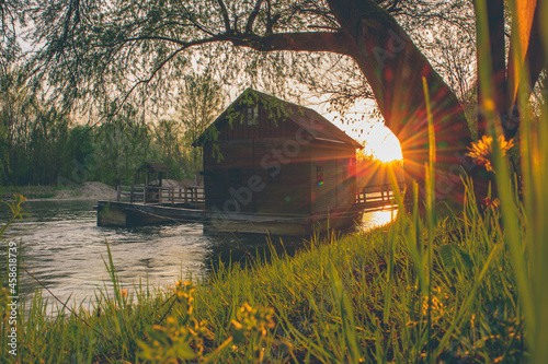 Beautiful old wooden mill on mura river or mlin na muri in the pomurje region of slovenia on a romantic summer sunset photo
