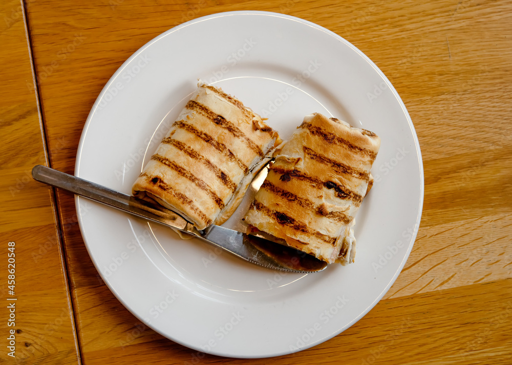 sliced sandwich on a white plate on the table in a cafe sliced sandwich on a white plate on the table in a cafe