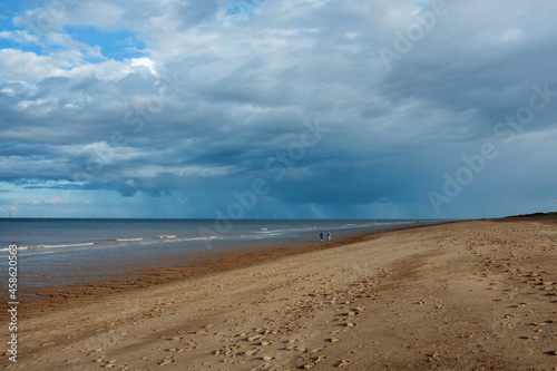 Sand beach, sea and cloudy blue sky in England in day