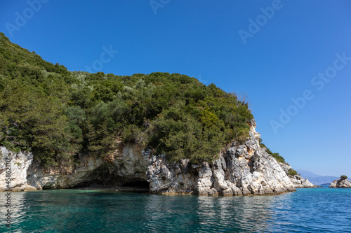 St.Nicholas Cave tourist attraction in green cliffs of Ionian Sea shore. Nature of Lefkada island in Greece. Summer vacation wild travel destination