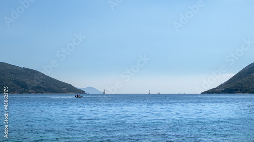 Blue Ionian sea landscape view on Lefkada Greece island. Sailing bright day with vivid sky and water. Boats sailing in distance