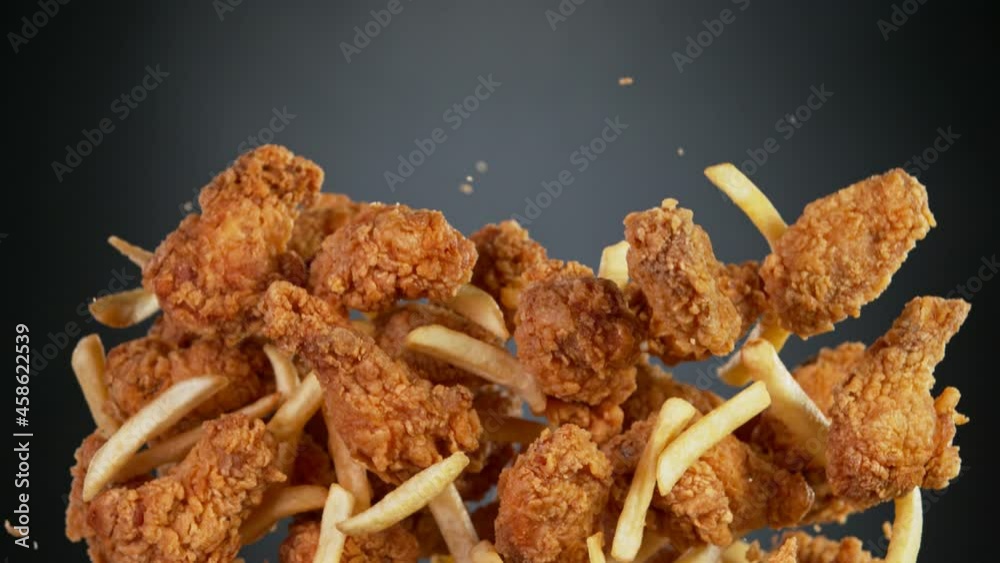 Super Slow Motion Shot of Flying Fresh Fried Chicken Wings or Strips. Filmed on High Speed Cinematic Camera at 1000 fps.