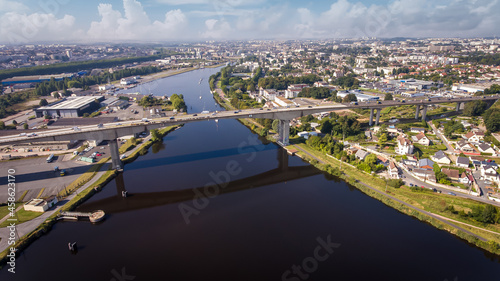 CAEN, FRANCE-SEPTEMBER 2021: Viaduc de Calix on the canal de caen. The largest bridge in Caen, an important road for cars. A photo from the drone, in the phone is buildings and greenery