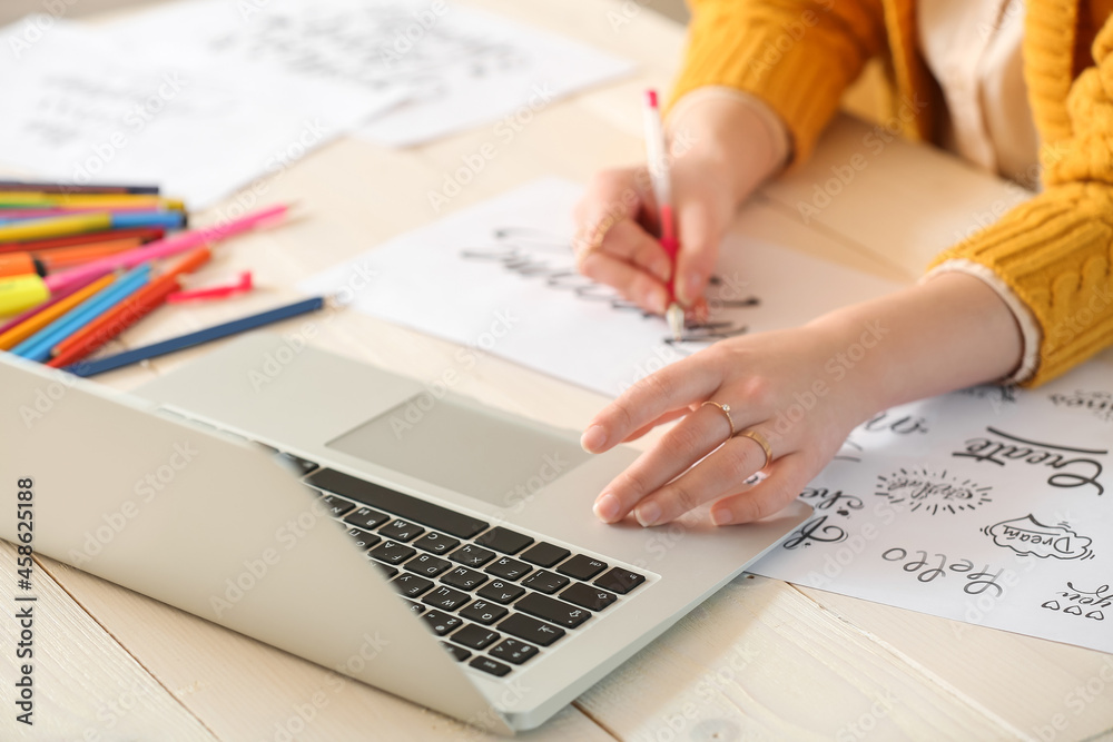Young female calligraphist working in office Young female calligraphist working in office