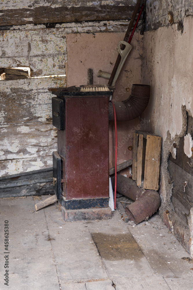 Old fuel boiler in the interior of a crumbling house (wooden house).